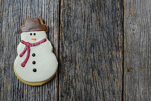Wall Art - Photograph - Snowman Cookie On Rustic Wood Background For Christmas by Brandon Bourdages