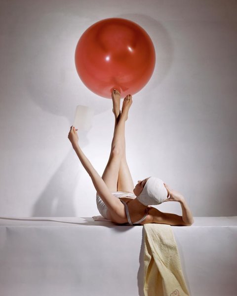 Wall Art - Photograph - A Model Balancing A Red Ball On Her Feet by Horst P Horst